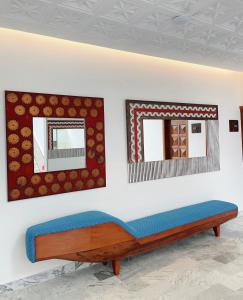 a bench in a room with two mirrors on the wall at Hotel Lepic in Abidjan