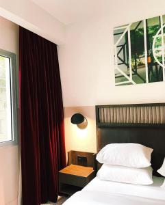 una camera d'albergo con letto e finestra di Hotel Lepic a Abidjan