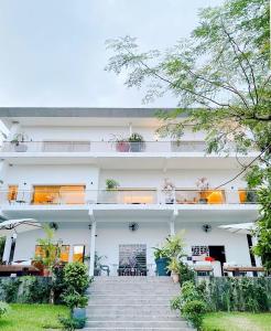 - un bâtiment blanc avec des escaliers devant dans l'établissement Hotel Lepic, à Abidjan