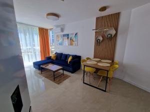 a living room with a blue couch and a table at Апартамент МеГи in Burgas