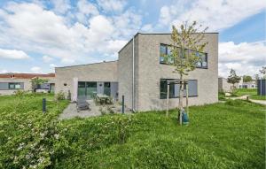 a gray brick house with a yard at Cozy Home In Lembruch-dmmer See With Sauna in Lembruch