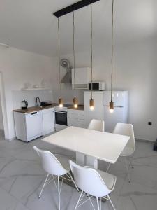 eine Küche mit einem weißen Tisch und weißen Stühlen in der Unterkunft Apartments Jamice in Novi Vinodolski