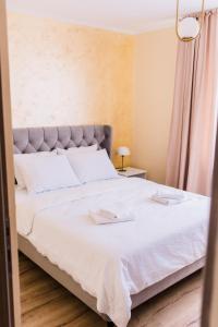 a bedroom with a large bed with white sheets at Central White Apartment in Satu Mare
