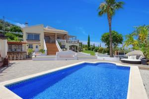 a villa with a swimming pool in front of a house at Castillo Esmeralda in Alhaurín de la Torre