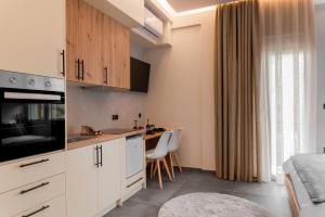 a kitchen with white cabinets and a table with chairs at DK APARTMENTS in Ioannina +33 photos
