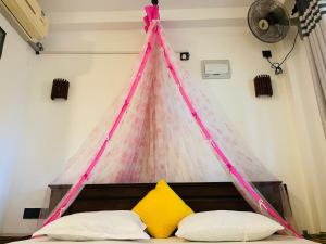 een bed met een tent erboven in een kamer bij Kosi Giggles Resort in Weligama