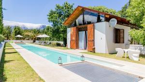 a villa with a swimming pool in front of a house at La Villa in Franschhoek