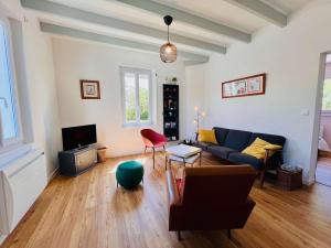 a living room with a couch and a tv at Maison rénovée 75m², 6 pers, proche plage et centre, jardin, terrasse, parking, WIFI - FR-1-478-186 in Quiberon
