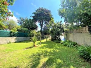a backyard with a fence and a grass yard at Maison rénovée 75m², 6 pers, proche plage et centre, jardin, terrasse, parking, WIFI - FR-1-478-186 in Quiberon