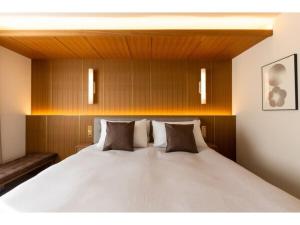 um quarto com uma grande cama branca e paredes de madeira em The OneFive Terrace Fukuoka - Vacation STAY 33419v em Fukuoka