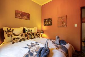 a bedroom with a bed with animals on it at Ijaba Lodge at Buschfeld Park in Outjo