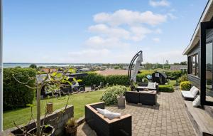 een terras met meubilair en uitzicht op een tuin bij 3 Bedroom Cozy Home In Juelsminde in Sønderby