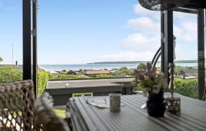 een tafel op een balkon met uitzicht op de oceaan bij 3 Bedroom Cozy Home In Juelsminde in Sønderby +15 foto's