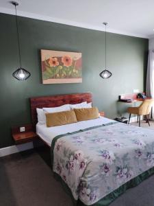 a bedroom with a bed and two lights on the wall at MyPond Stenden Hotel in Port Alfred