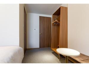 een slaapkamer met een bed, een tafel en een kast bij The OneFive Terrace Fukuoka - Vacation STAY 33431v in Fukuoka