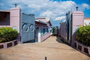 a street with pink and purple buildings and bushes at The Alca Villa in Kigali