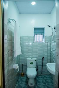 a bathroom with a white toilet and a sink at The Alca Villa in Kigali