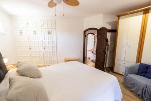 Un dormitorio con una cama blanca y una silla. en Catalunya Casas Incredible & Unique Costa Dorada Abode!, en Creixell
