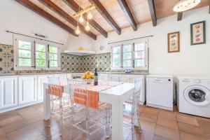 a kitchen with a white table and chairs at Finca Can Suau in Pollença