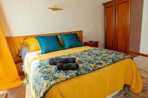 a bedroom with a bed with blue and yellow sheets at La Rosée - Studio Campagne à 50m des Thermes - Vue jardin, Wifi, Smart TV in Bourbonne-les-Bains