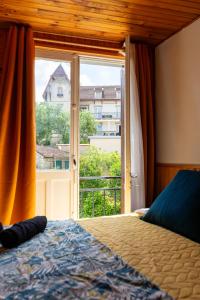 sypialnia z łóżkiem i dużym oknem w obiekcie La Rosée - Studio Campagne à 50m des Thermes - Vue jardin, Wifi, Netflix, Smart TV w mieście Bourbonne-les-Bains