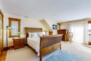 ein Schlafzimmer mit Bett, Schreibtisch und Fenster in der Unterkunft Cape Springs Cottage in Chatham