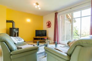 a living room with two chairs and a television at An den Boddenwiesen 02 in Wieck