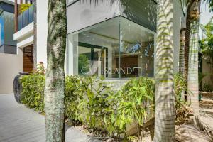 un devant de magasin avec des arbres devant un bâtiment dans l'établissement Villa 4 chambres, moderne, piscine, à Grand Baie proche des plages, à Grand Baie