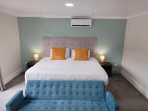 a bedroom with a large bed and a blue couch at MyPond Stenden Hotel in Port Alfred