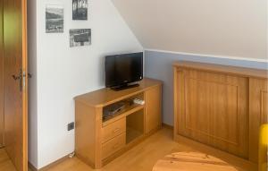 a living room with a tv on a wooden cabinet at 4 Bedroom Awesome Home In Oberaula Ot Hausen in Hausen