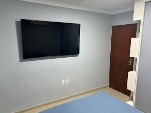 Una habitación con un televisor de pantalla plana en la pared. en SEU LAR, en Campina Grande