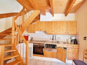 a kitchen with wooden cabinets and a spiral staircase at Natur-Ferienpark in Nieheim