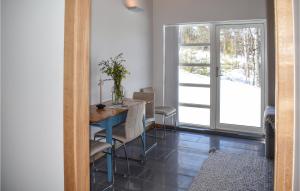 a dining room with a table and a window at Lovely Home In Geilo With Kitchen in Dagali