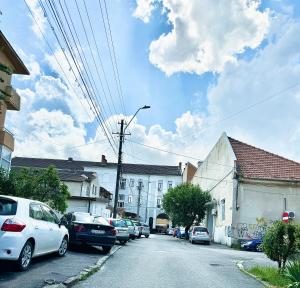 a street with cars parked on the side of the road at Bri Central Apartment in Deva