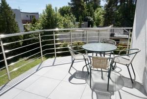 a patio with a table and chairs on a balcony at Promyczek in Krynica Morska