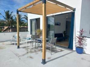 a pavilion with a table and chairs on a patio at Appartement moderne face à la mer in Mahébourg