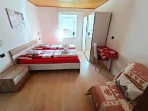 a bedroom with two beds and a table in it at Casa Paola in Pozza di Fassa +60 photos
