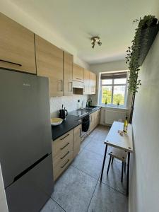 une cuisine avec un réfrigérateur et une table à l'intérieur dans l'établissement Apartament pod Czerwonym Pagajem Gdynia, à Gdynia 7 autres photos