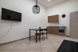 a living room with a table and a tv on a wall at Casa Vacanze Nemesi AURA in Salerno
