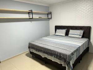 um quarto com uma cama com duas almofadas em SEU LAR em Campina Grande