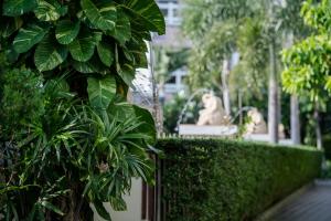 a garden with a statue in the background at Neptune's Villa in Haad Rin