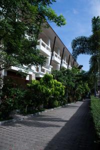 a large white building with trees and a sidewalk at Neptune's Villa in Haad Rin