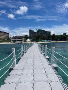 un ponte sull'acqua con una città sullo sfondo di Condo with Private Beach at Tambuli Beach Resort near Airport in Cebu a Lapu Lapu City
