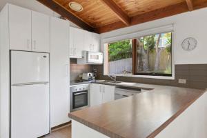 托基Sunset Sanctuary 500m to beach Pet Friendly的一间厨房,配有白色家电和大窗户