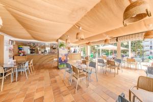 um restaurante com mesas e cadeiras e um balcão em Apartamentos Vista Club em Santa Ponsa
