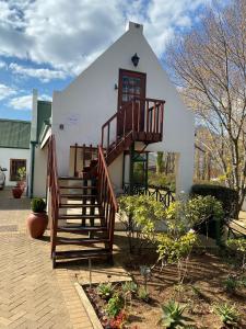 a house with a staircase in front of it at The Gables-Clarens in Clarens