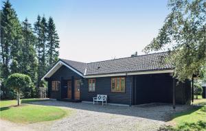 a small black cabin with a porch at Three-Bedroom Holiday Home In Oksbol in Oksbøl