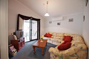 a living room with a couch and a table at Serenity Grove in Broke