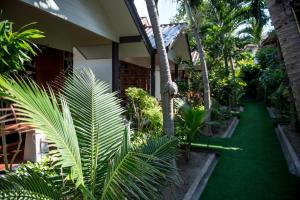a garden with palm trees and a green lawn at Neptune's Villa in Haad Rin