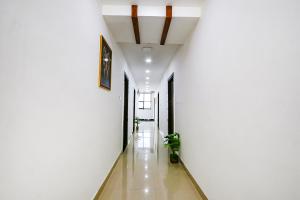 a hallway with white walls and a potted plant at FabHotel VK's in Hyderabad